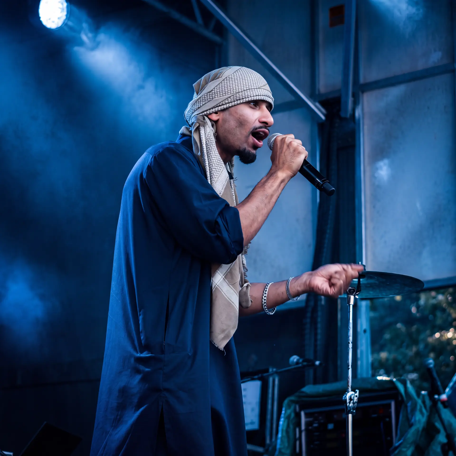 Singer performing on stage beneath blue lights