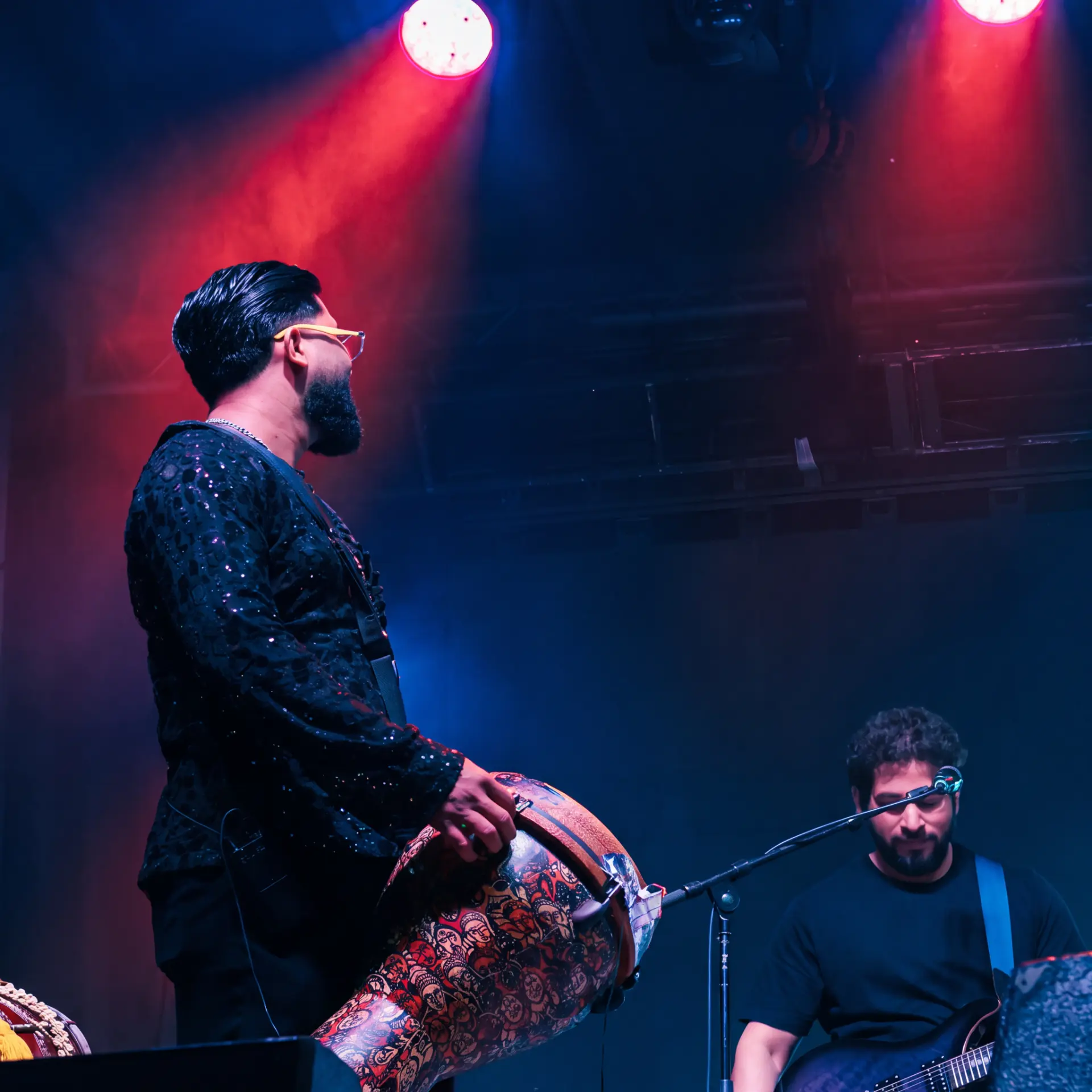 Percussionist playing on stage under red and blue lights