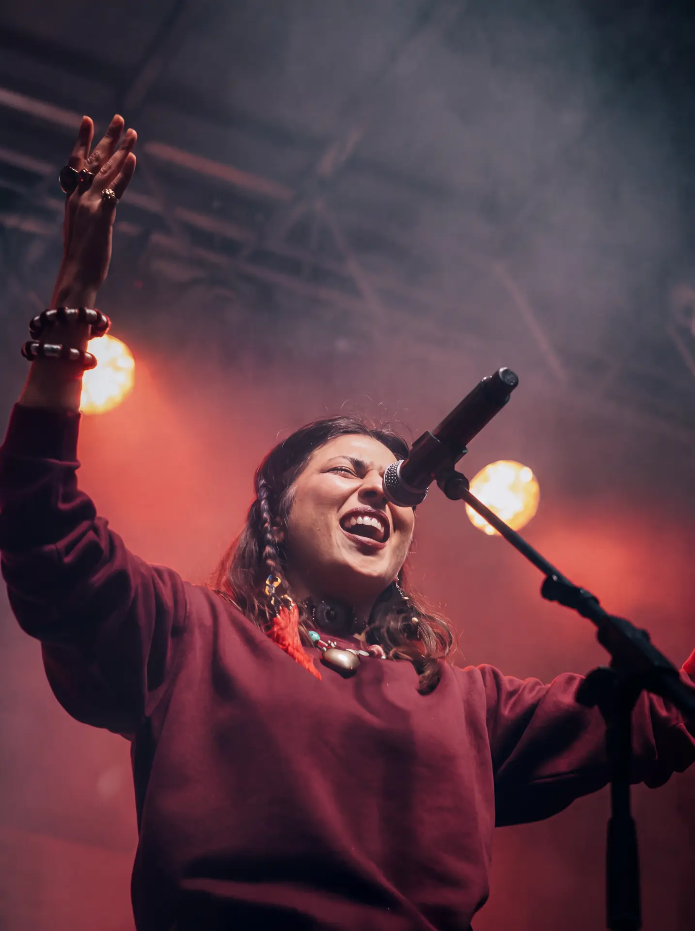 Singer laughing mid-performance with an arm raised