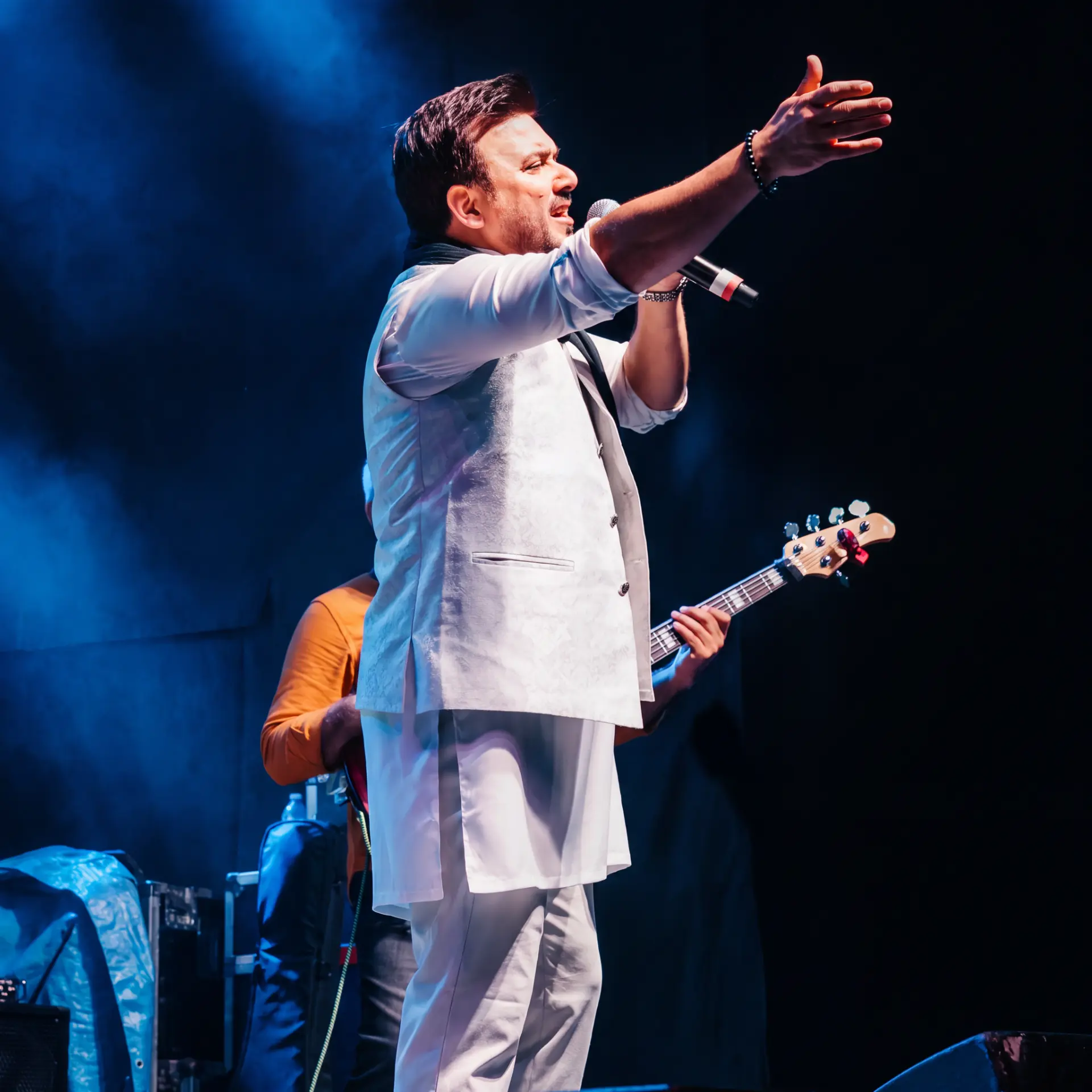 Singer gesturing to the crowd while performing on stage